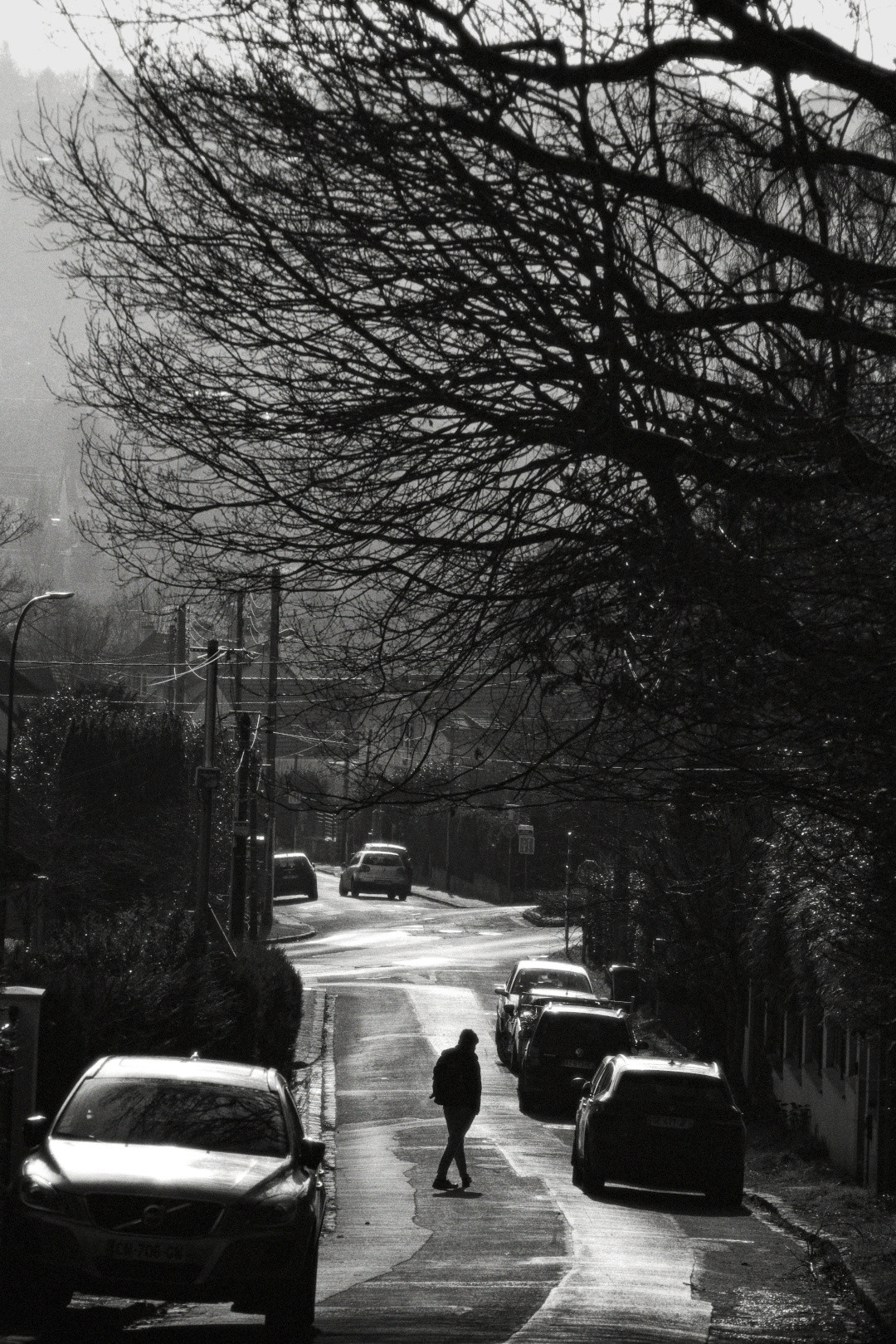 Silhouette of a person crossing a street in high-contrast black and white